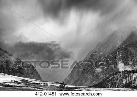 Stock Image - Clouds over snowy rural landscape. Fotosearch