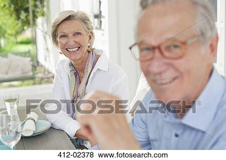 Stock Photo - Couple smiling together at table. Fotosearch