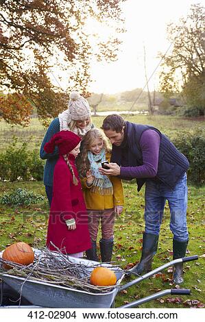 Family using cell phone together outdoors View Large Photo Image Picture - Family using cell phone together outdoors. Fotosearch