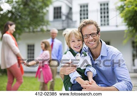 Father and son smiling outside house View Large Photo Image Stock Photography - Father and son smiling outside house. Fotosearch