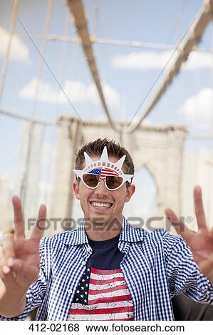 Stock Photo - Man in novelty sunglasses on urban bridge. Fotosearch