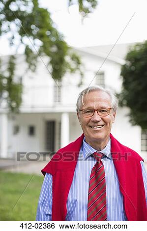 Stock Photograph - Man smiling outside house. Fotosearch