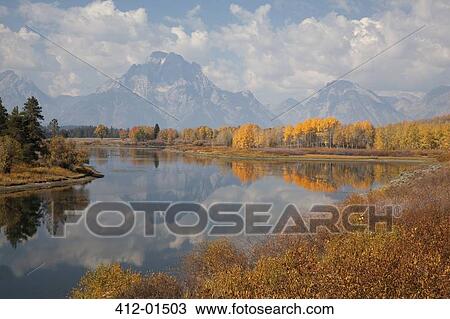 Stock Image - Mountains and sky reflected in still river. Fotosearch