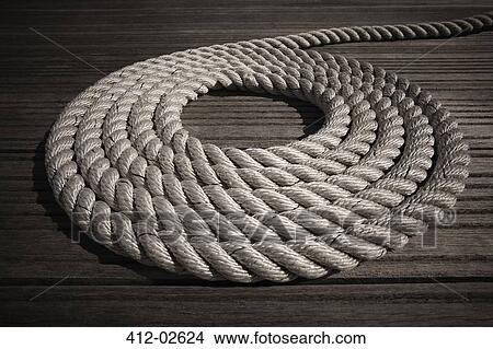 Rope coiled in circle on boardwalk View Large Photo Image Picture - Rope coiled in circle on boardwalk. Fotosearch