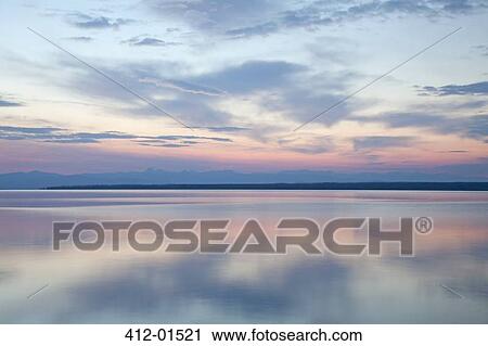 Sunrise reflected in still water View Large Photo Image Stock Image - Sunrise reflected in still water. Fotosearch