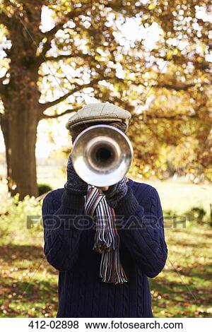 Stock Photo - Teenage boy playing trumpet outdoors. Fotosearch