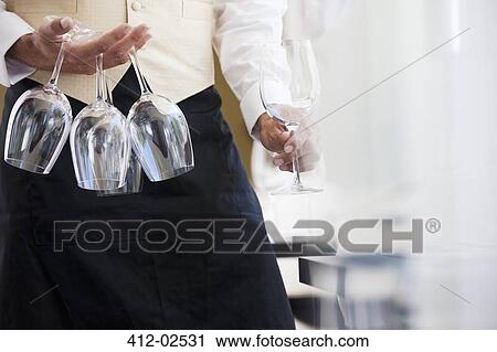Waiter carrying wine glasses in restaurant View Large Photo Image Stock Image - Waiter carrying wine glasses in restaurant. Fotosearch