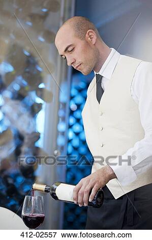 Stock Photo - Waiter pouring glass of wine in restaurant. Fotosearch
