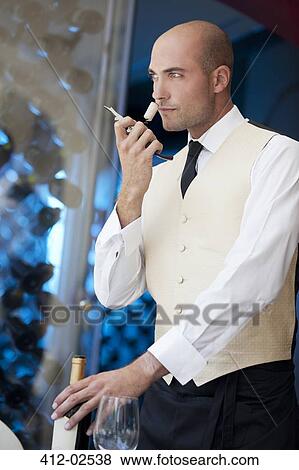 Waiter smelling wine cork in restaurant View Large Photo Image Stock Photo - Waiter smelling wine cork in restaurant. Fotosearch