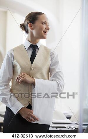 Stock Image - Waitress smiling in restaurant. Fotosearch