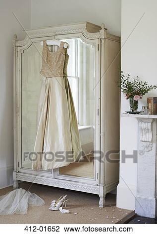 Wedding gown hanging from wardrobe View Large Photo Image Stock Image - Wedding gown hanging from wardrobe. Fotosearch