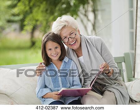Stock Photo - Woman and granddaughter smiling in porch swing. Fotosearch
