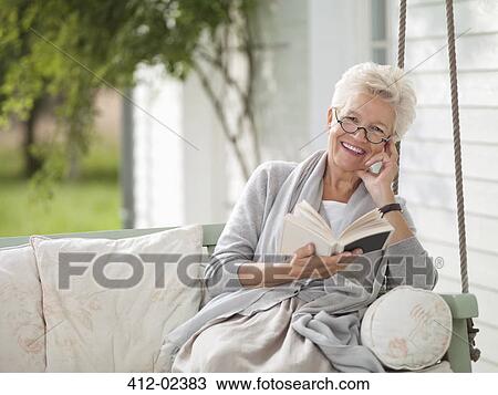 Woman reading in porch swing View Large Photo Image Stock Image - Woman reading in porch swing. Fotosearch