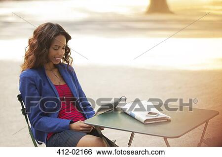Woman using digital tablet in park View Large Photo Image Stock Photograph - Woman using digital tablet in park. Fotosearch