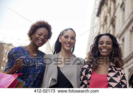 Stock Image - Women walking together on city street. Fotosearch