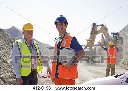 Worker and businessman standing in quarry View Large Photo Image Stock Image - Worker and businessman standing in quarry. Fotosearch