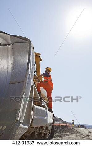 Worker climbing machinery in quarry View Large Photo Image Stock Photo - Worker climbing machinery in quarry. Fotosearch