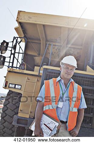 Worker holding clipboard on site View Large Photo Image Stock Image - Worker holding clipboard on site. Fotosearch