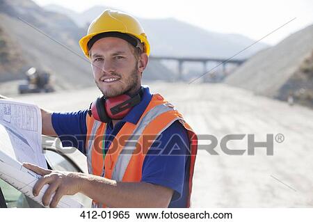 Worker reading blueprints in quarry View Large Photo Image Stock Photography - Worker reading blueprints in quarry. Fotosearch