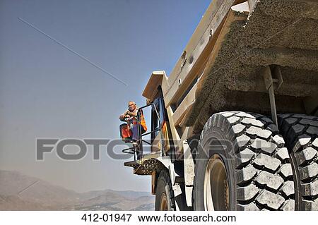 Worker standing on machinery View Large Photo Image Stock Photo - Worker standing on machinery. Fotosearch
