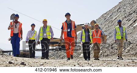 Workers and business people walking in quarry View Large Photo Image Stock Photograph - Workers and business people walking in quarry. Fotosearch