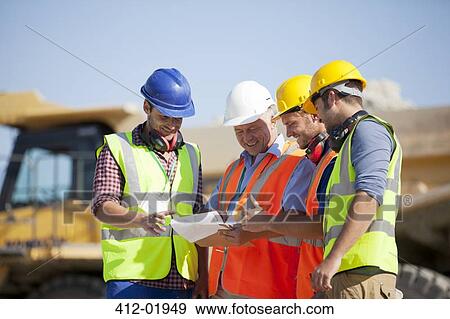 Stock Photo - Workers and businessman talking in quarry. Fotosearch