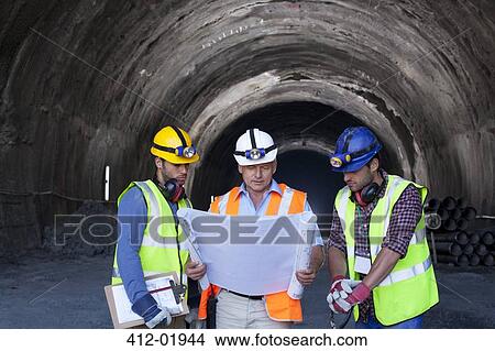 Workers and businessman with blueprints in tunnel View Large Photo Image Picture - Workers and businessman with blueprints in tunnel. Fotosearch