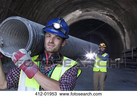 Workers carrying long pipe in tunnel View Large Photo Image Stock Image - Workers carrying long pipe in tunnel. Fotosearch