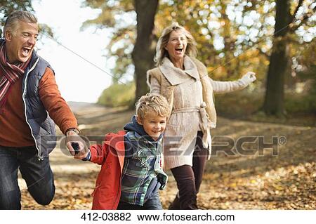 Boy and grandparents walking in park View Large Photo Image Stock Image - Boy and grandparents walking in park. Fotosearch
