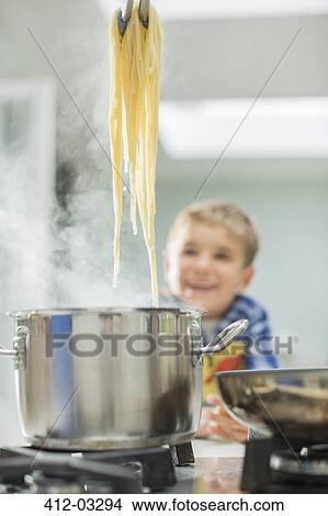 Boy watching parent cook spaghetti View Large Photo Image Picture - Boy watching parent cook spaghetti. Fotosearch