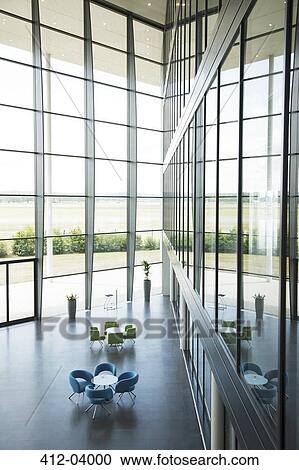 Stock Image - Chairs and tables in office lobby area. Fotosearch