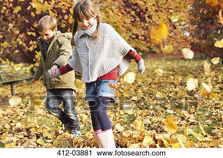 Children playing in autumn leaves View Large Photo Image Stock Image - Children playing in autumn leaves. Fotosearch