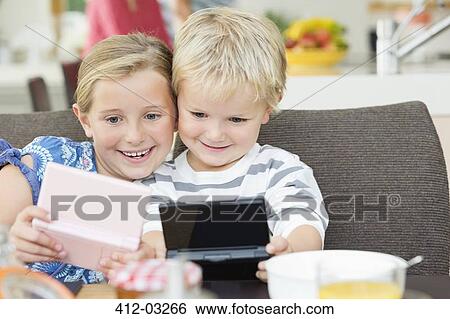Children playing video games at breakfast View Large Photo Image Stock Photograph - Children playing video games at breakfast. Fotosearch