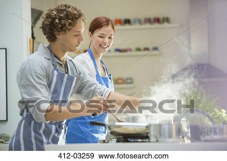 Couple cooking in kitchen View Large Photo Image Stock Photo - Couple cooking in kitchen. Fotosearch