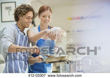 Couple cooking in kitchen View Large Photo Image Stock Photo - Couple cooking in kitchen. Fotosearch