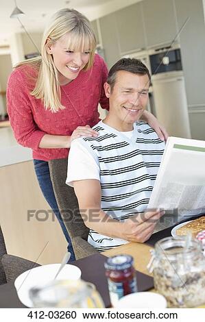 Couple reading newspaper at breakfast View Large Photo Image Stock Image - Couple reading newspaper at breakfast. Fotosearch