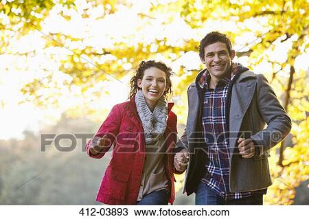 Stock Image - Couple walking in park. Fotosearch