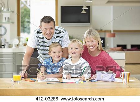 Stock Photograph - Family smiling together at table. Fotosearch