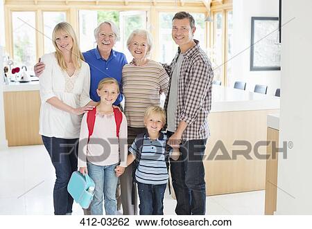 Stock Image - Family smiling together in kitchen. Fotosearch