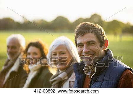 Family smiling together in park View Large Photo Image Stock Image - Family smiling together in park. Fotosearch
