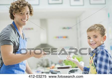 Stock Photography - Father and son baking in kitchen. Fotosearch