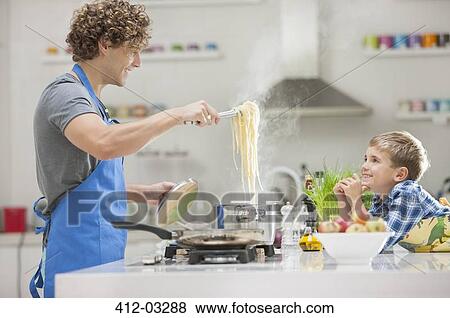 Stock Photo - Father and son cooking in kitchen. Fotosearch
