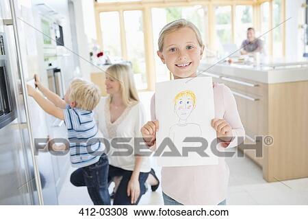 Girl showing off drawing in kitchen View Large Photo Image Stock Photo - Girl showing off drawing in kitchen. Fotosearch