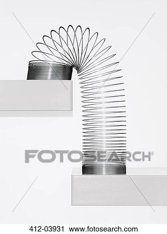 Metal slinky cascading down steps View Large Photo Image Stock Image - Metal slinky cascading down steps. Fotosearch