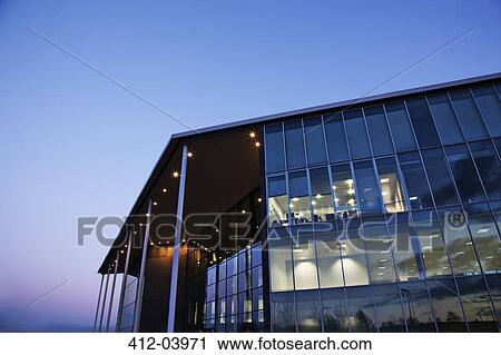 Stock Image - Modern building illuminated at sunset. Fotosearch