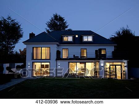 Stock Photograph - Modern house illuminated at night. Fotosearch