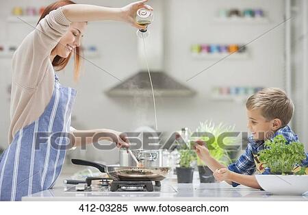 Stock Photography - Mother and son cooking in kitchen. Fotosearch