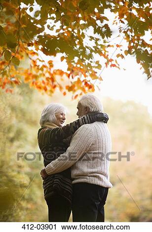 Older couple hugging in park View Large Photo Image Stock Image - Older couple hugging in park. Fotosearch