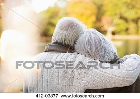 Stock Photo - Older couple hugging in park. Fotosearch