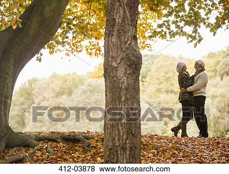 Older couple hugging in park View Large Photo Image Stock Photo - Older couple hugging in park. Fotosearch